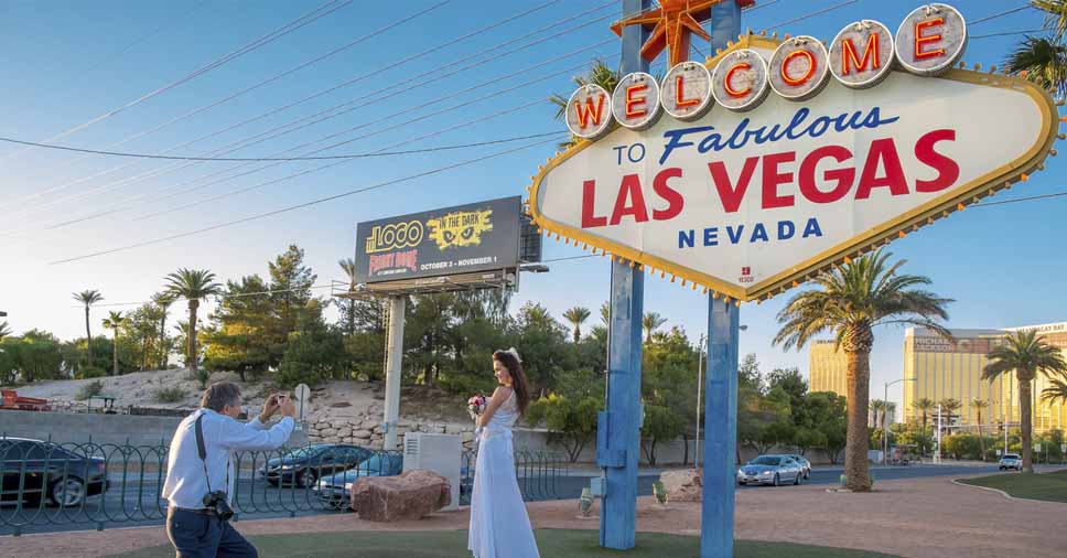 Noiva tirando foto no ponto turístico de Las Vegas. Veja como funciona o casamento no exterior!